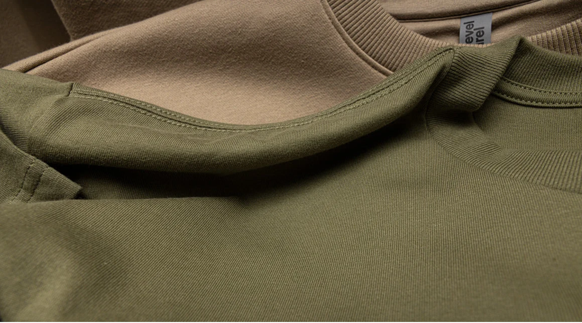 Olive green Next Level Apparel tee layered over a warm tan heavyweight crewneck sweatshirt in earthy fall colors