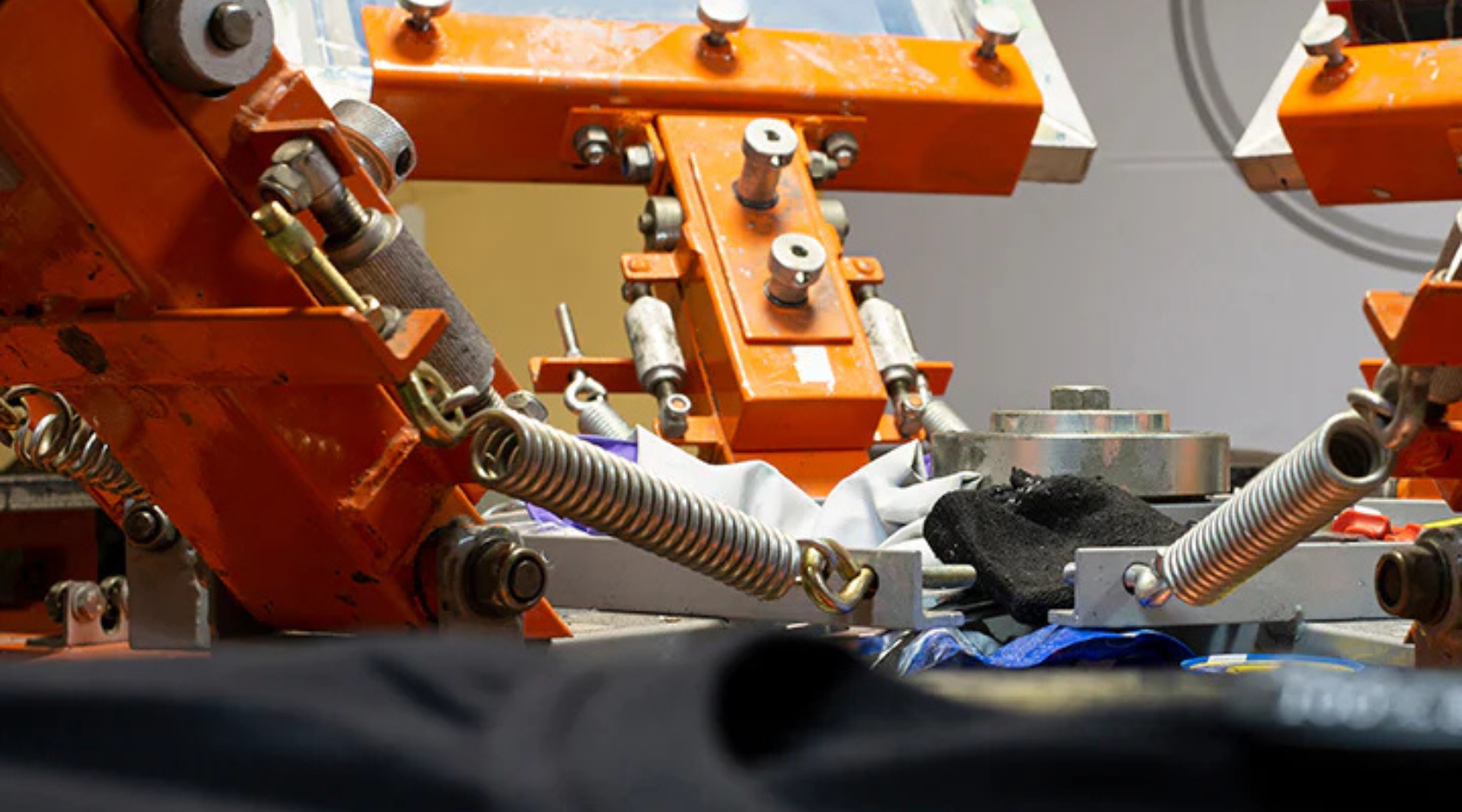 Close-up of a screen printing machine pressing ink onto a t-shirt