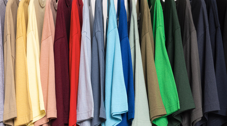 A rack of colorful t-shirts in spring 2026 trending shades including yellow, pink, blue, green, and neutral tones